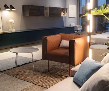 Table d'appoint ronde Orbis par Novamobili dans un salon moderne, près d'un fauteuil en cuir marron et d'un tapis.
