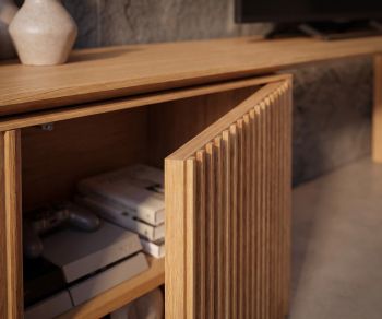 Buffet TV Punt Velasca en chêne massif avec porte à liteaux ouverte montrant le rangement intérieur dans un salon design.