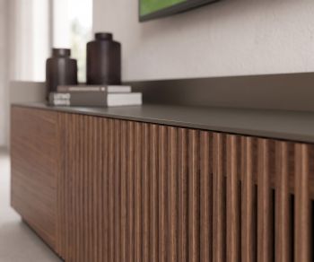 Meuble TV bas Punt Stockholm avec façade en tasseaux de noyer et plateau alu dans un salon moderne.